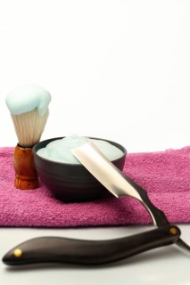 Shaving brush with foam, cream and straight razor are ready for a traditional wet shave