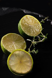 Three lime slices on a black stone plate