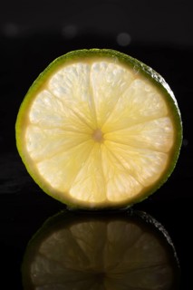 Slice of lime on stone slab with reflection