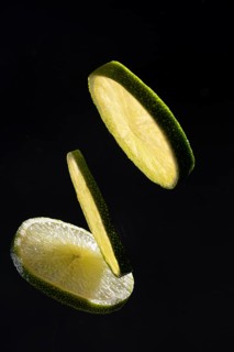 Three lime slices on a black background