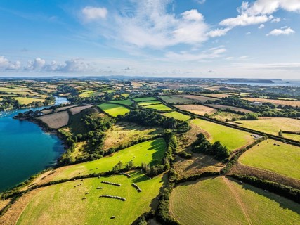 Farms and Fields over St Mawes from drone, Carrick Roads, River Fal, Falmouth, Cornwall, UK
