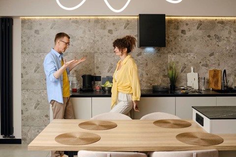 The husband explains his ideas to the young wife actively gesturing his hands during a conversation