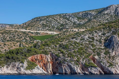 View from the sea to the red rocks, island of Hvar, Dalmatia, Croatia