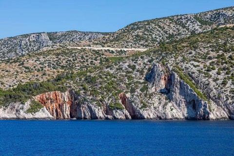 View from the sea to the red rocks, island of Hvar, Dalmatia, Croatia