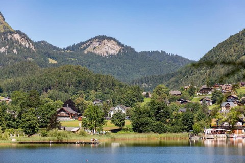 Idyllic landscape with houses by the lake, framed by wooded hills and mountains, Altaussee, Styria,