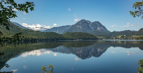 Peaceful lake surface with mountain panorama, Dachstein and Sarstein, cloud reflection in the