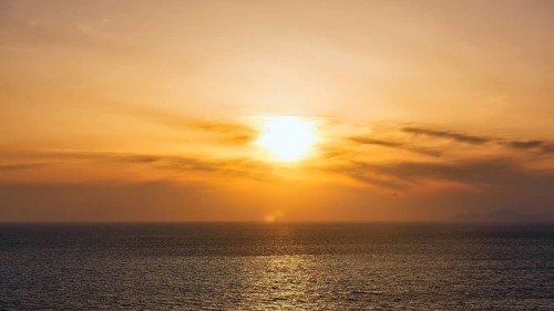 Evening sun behind Cirrus, golden sunset by the sea, Oia, Thira, Santorini, Cyclades, Greece
