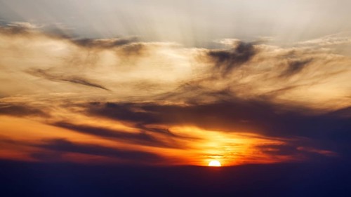 Sunset behind cloud cover, sunbeams, Oia, Thira, Santorini, Cyclades, Greece