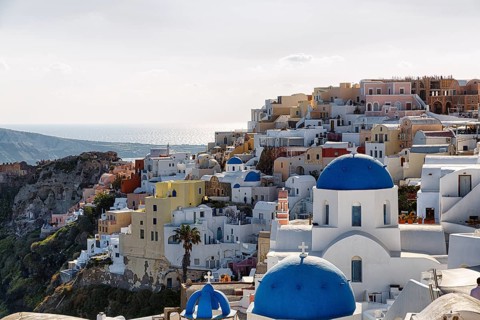 Typical architecture with white or colourfully whitewashed holiday homes and blue roofs, churches