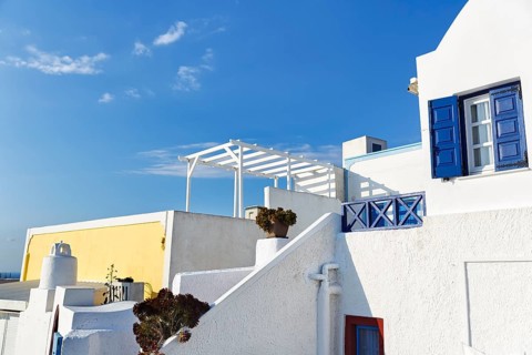 Architectural detail, typical white holiday homes, yellow wall, blue sky, Oia, Thira, Santorini,