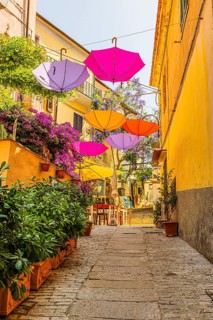 Coloured umbrellas span the Via Cavour, Capoliveri, Elba Island, Tuscan Archipelago National Park,