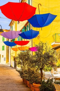 Coloured umbrellas span the Via Cavour, Capoliveri, Elba Island, Tuscan Archipelago National Park,