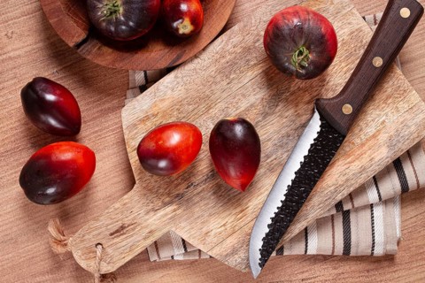 Sliced tomatoes, Black Beauty variety, on a cutting board, top view, on the kitchen table