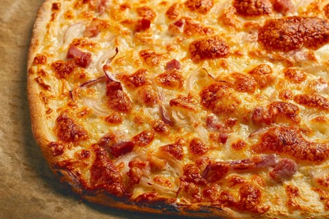 Tart flambe, open pie, rectangular pizza, with cheese and red onion, bacon slices, Alsatian dish,