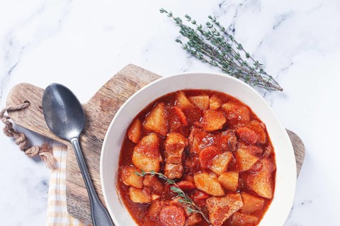 Meat goulash with potatoes and carrots, sweet peppers, in a saucepan, top view, traditional