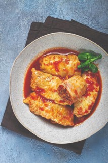 Stuffed cabbage rolls with minced meat, in tomato sauce, top view, without people, in the spotlight