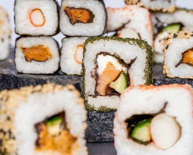 Various sushi dishes on dark grey stone surface