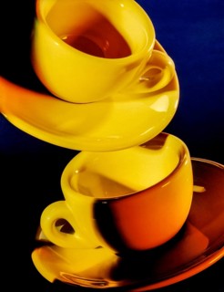 Bright illuminated yellow cups with saucer in dark blue back