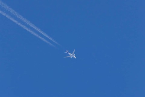 Airbus A300-600RF jet aircraft of FedEx Express airlines in flight in a blue sky with vapour trails