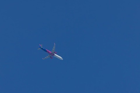 Airbus A321 jet aircraft of Wizz Air airlines in flight in a blue sky, England, United Kingdom