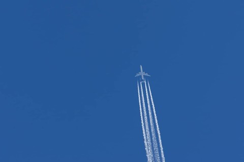 Airbus A340-300 jet aircraft of Lufthansa airlines in flight in a blue sky with vapour trails or