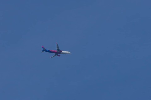 Airbus A321 jet aircraft of Wizz Air airlines in flight in a blue sky, England, United Kingdom