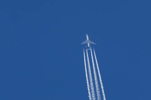 Airbus A340-300 jet aircraft of Lufthansa airlines in flight in a blue sky with vapour trails or