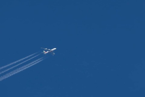 Airbus A380 jet passenger aircraft of Emirates airlines in flight in a blue sky with vapour trails