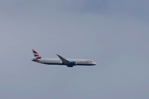 Boeing 787-9 Dreamliner jet passenger aircraft of British Airways airlines in flight in a blue sky,