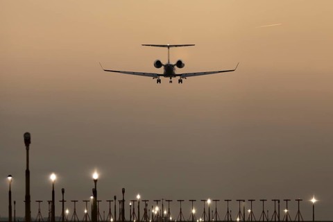 Bombardier Global business jet passenger aircraft in flight landing at sunset at London Stansted