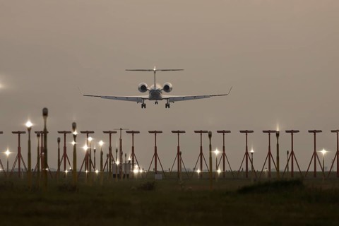 Bombardier Global business jet passenger aircraft in flight landing at sunset at London Stansted