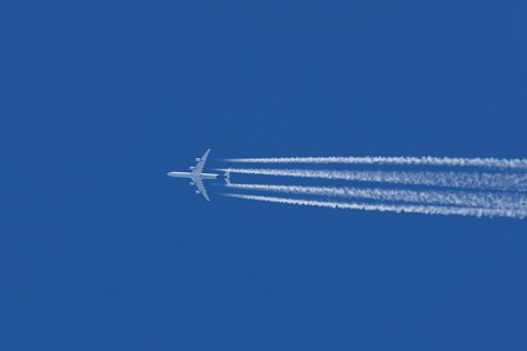 Airbus A340-300 jet aircraft of Lufthansa airlines in flight in a blue sky with vapour trails or