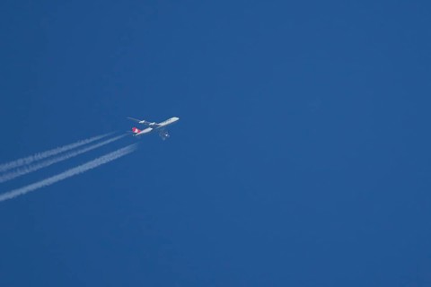Boeing 747 Jumbo jet cargo aircraft of Cargolux airlines in flight in a blue sky with vapour trails