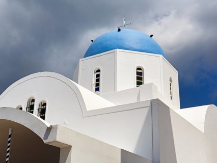 Orthodox church with blue dome, dramatic cloudy sky, Firostefani, Thira, Santorini, Cyclades,