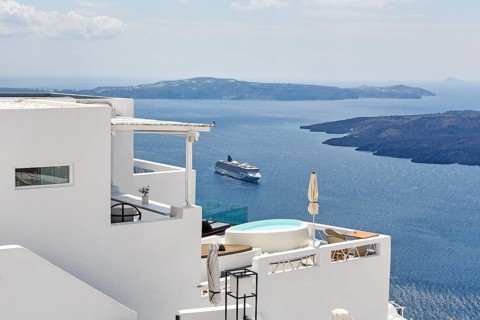 Characteristic white holiday homes with views of the caldera and the Aegean Sea, cruise ship,