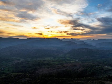 Sunset over Mountains and Coniston Water from drone, Lake District National Park, Cumbria, England,