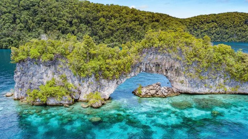 Aerial view bird's eye view through rock arch Natural Arch in lagoon of island paradise island