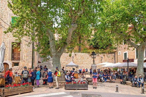 Many tourists in the square with outdoor restaurants in Fornalutx an old idyllic village in