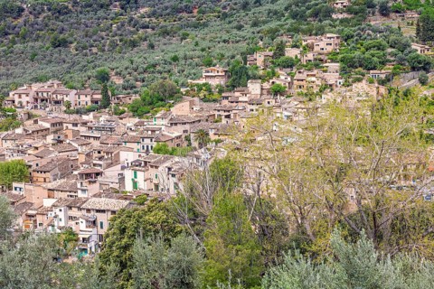 View at an old mountain village with residential houses on a slope with lush green trees,