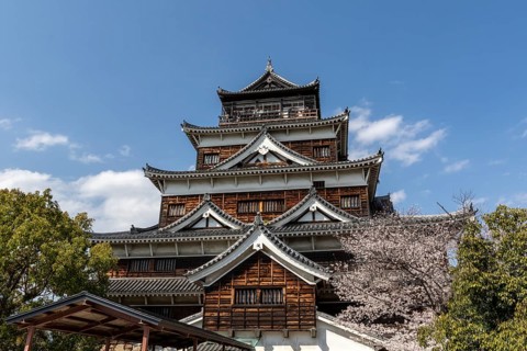 Hiroshima Castle, also known as Carp Castle, in front of a blue sky with cherry blossoms, Sakura,