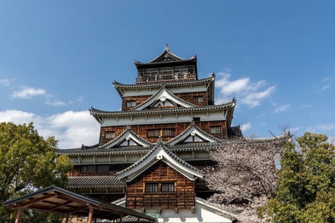 Hiroshima Castle, also known as Carp Castle, in front of a blue sky with cherry blossoms, Sakura,
