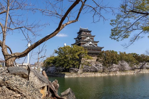 Hiroshima Castle, also known as Carp Castle, against a blue sky, moat, replica of the original