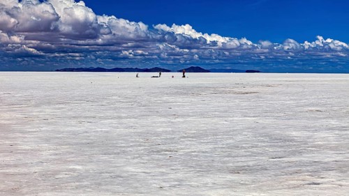 Vast salt desert with small animal-like creatures and clouds in the blue sky, The endless expanses