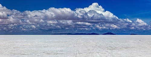 Wide cloud formation over a vast salt flat with distant mountain ranges, The endless expanses of