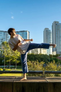 Young man demonstrating a powerful kick in an urban setting