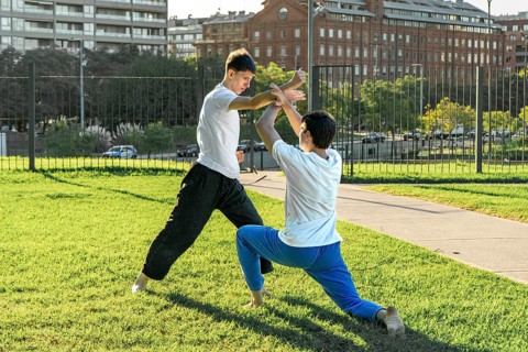 Young martial artists practicing a grappling hold outdoors