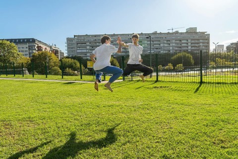 Two young men performing aerial Taekwondo kicks with copy space