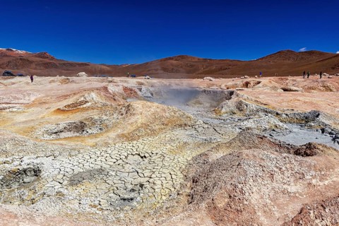 Vast geothermal landscape in a dry desert under a clear sky, The mud volcanoes and fumaroles on the