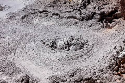 Active grey mud pool with bubbles in geothermal area, The mud volcanoes and fumaroles on the