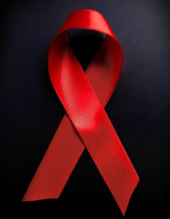 Close-up of a red awareness ribbon symbolizing support for causes like HIV/AIDS and heart disease,